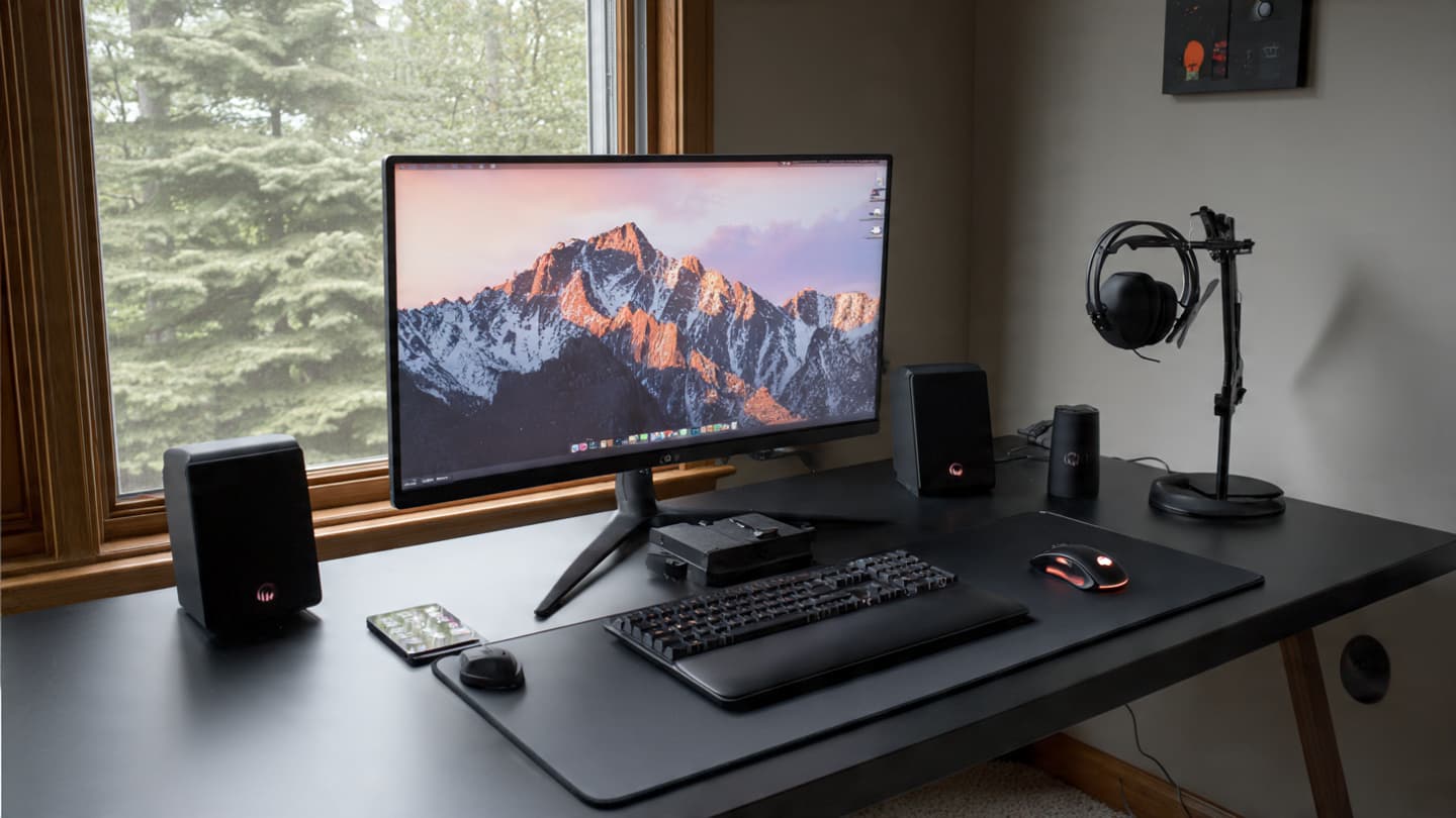 Minimal all black desk setup with clean surface