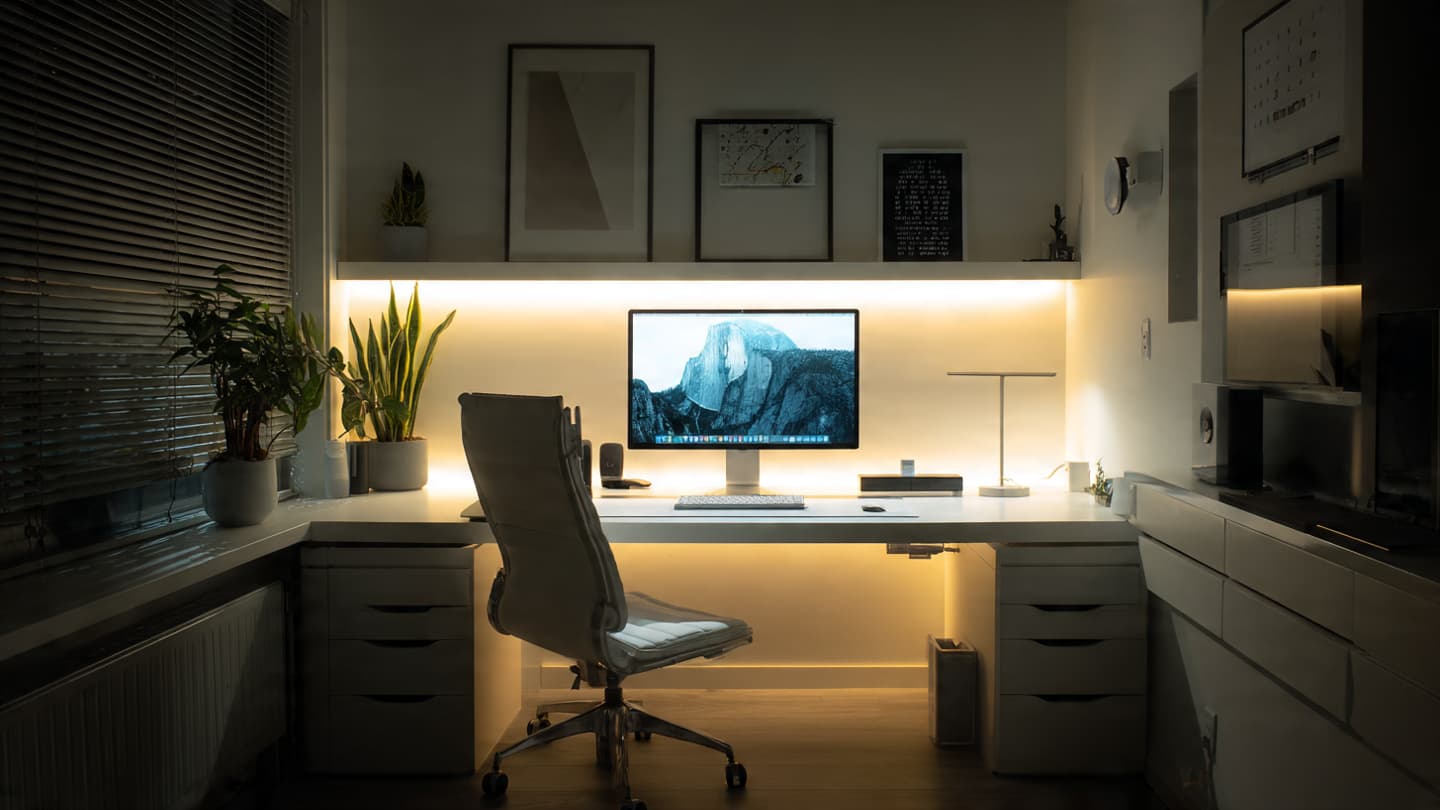 White minimalist desk at night with soft ambient lighting